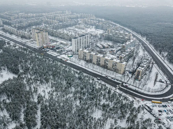 aerial view of apartment buildings on snowy streets surrounded with forest, Kyiv, Ukraine