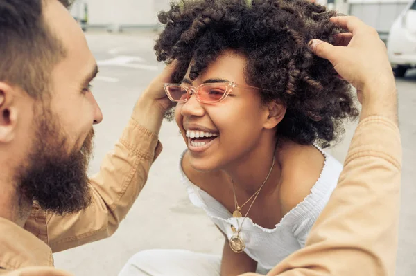 cropped shot of happy young interracial couple having fun and laughing on street