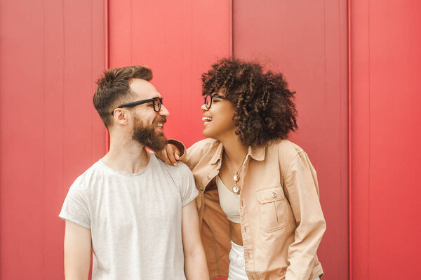 beautiful happy young multiethnic couple in eyeglasses smiling each other