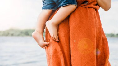 bir anne oğlunun Nehri yakınında tutarak resim kırpılmış