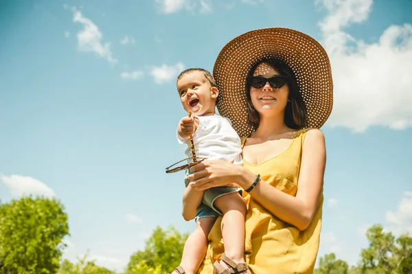 Visão Baixo Ângulo Mãe Óculos Sol Chapéu Palha Segurando Filho — Fotografia de Stock