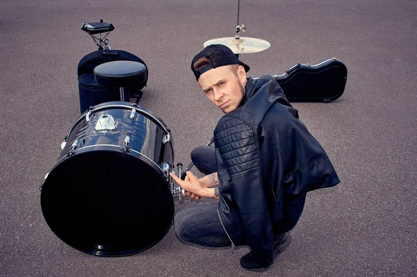 Schlagzeuger Schwarzer Kleidung Zeigt Auf Schlagzeug Auf Der Straße — kostenloses Stockfoto
