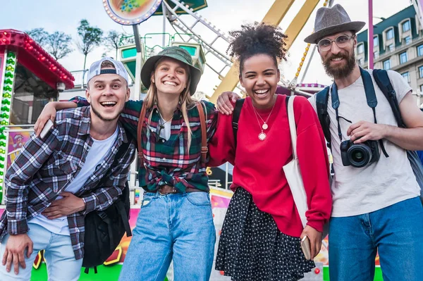 Fröhliche junge multiethnische Freunde, die im Freizeitpark zusammenstehen und in die Kamera lächeln — Stockfoto