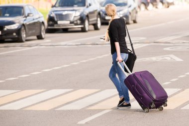 Telefon elleri ve kot kızla bir yaya geçidi bavula ile yola çıktı