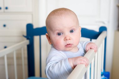 Küçük bir çocuk yatakta duruyor ve yan tarafa ellerimi.