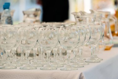 Beyaz masa örtüsü ile bir tabloda temiz boş şarap bardakları standı