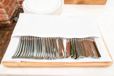 temiz bir restoran masada ahşap bir tepsi üzerinde beyaz bir havlu altında çatal yemek