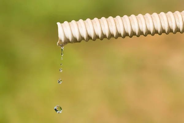 Tetesan Air Yang Jatuh Dari Selang Air Dari Latar Belakang — Stok Foto