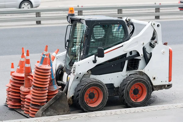 white city excavator with road cones in the bucket, special equipment