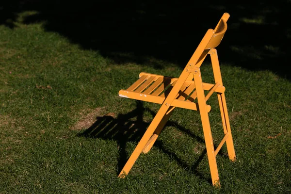 Gelber Klappstuhl Aus Holz Der Sonne Auf Dem Grünen Gras — Stockfoto