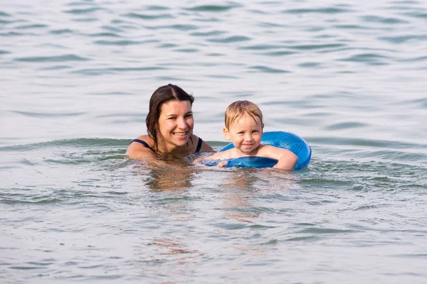 Young mother swims with her son in the sea Royalty Free Stock Images