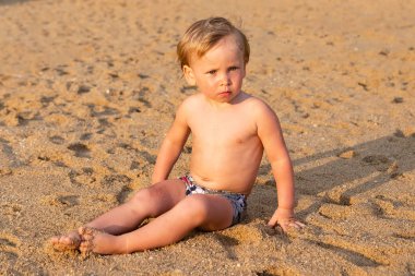 Sahilde oturmuş çocuk