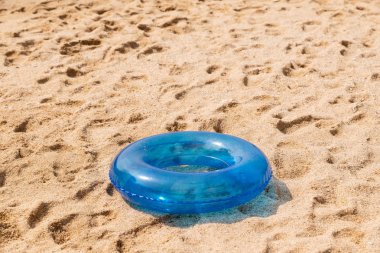 Kum üzerinde mavi şişme yüzme daire