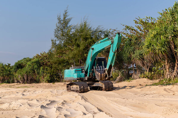 Excavator rides on the sea sand