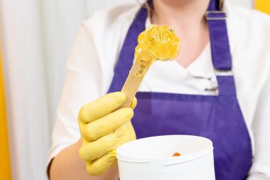 Kadın vücudundan şekerleme için şeker ezmesi ile saç kaldırma işlemi