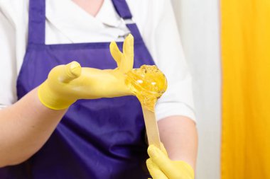 Kadın vücudundan şekerleme için şeker ezmesi ile saç kaldırma işlemi