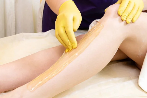 The process of removing hair with sugar paste for sugaring from the female body