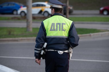Üniformalı polis memuru yolda arka görüşte duruyor