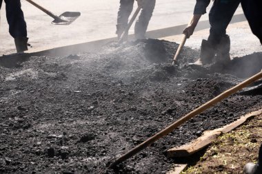 Yol Üreticileri Asfalt-Teamwork koydu. Asfaltobetonnye üzerinde çalışıyoruz. d. Sıcak asfalt çakıl, seviye işçileri.