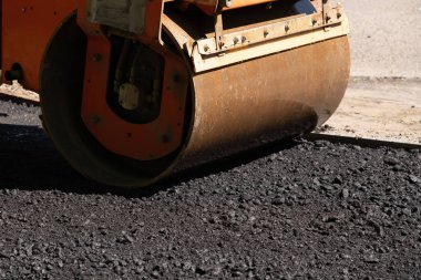 Turuncu yol silindiri çakıl ile taze sıcak siyah asfalt kompakt