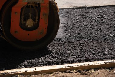 Turuncu yol silindiri çakıl ile taze sıcak siyah asfalt kompakt