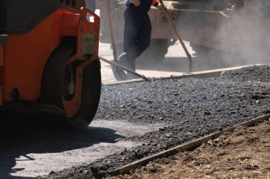Turuncu yol silindiri çakıl ile taze sıcak siyah asfalt kompakt