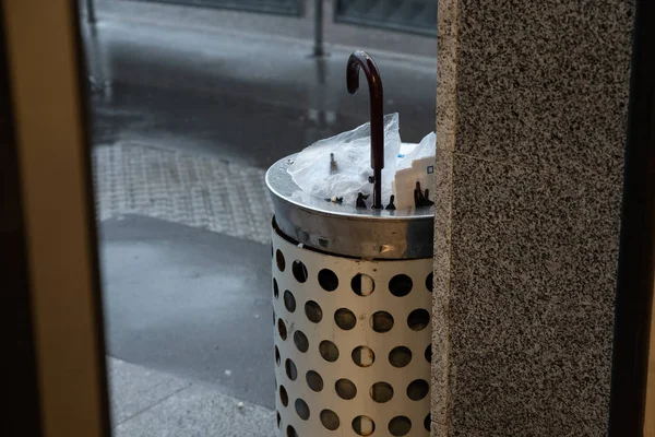 Quebrado por um forte guarda-chuva vento em uma urna de rua perto da entrada do metrô — Fotografia de Stock