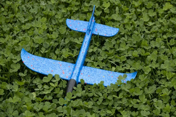 Mainan biru terbang di atas rumput hijau — Stok Foto