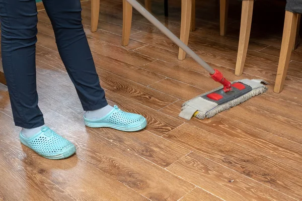 Woman hands hold mop cleans the floor — 스톡 사진