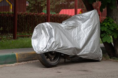 Koruyucu bir yansıtıcı kapakla kaplı motosiklet