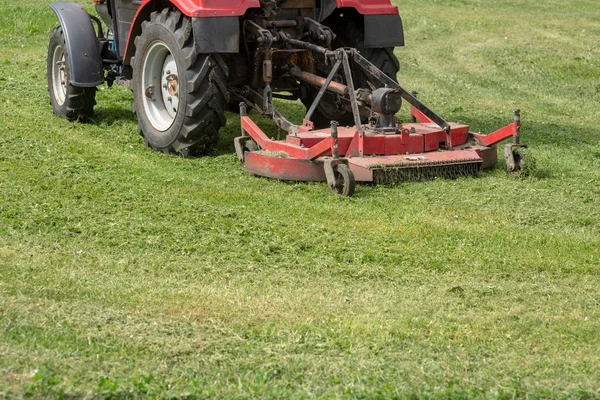 Sebuah traktor dengan mesin pemotong rumput hijau — Stok Foto