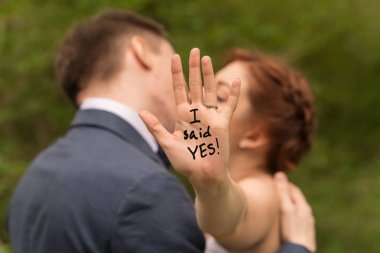 Aşk kucaklayan genç ırklar arası çiftin romantik portresi. Daha yeni nişanlandım. Elmas nişan yüzüğüne ve avuç içinize yazıya odaklanarak sığ alan derinliği.