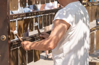 Sokakta metal plakalar üzerinde müzik çalan bir adam