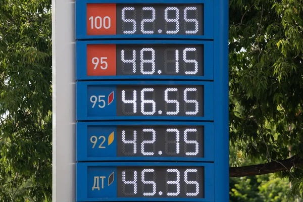 Ceny na informační tabuli benzinové pumpy. Čísla na kovové ploše s mechanicky pohyblivými kryty. Nápis-cyrilice: motorová nafta a zemní plyn. — Stock fotografie