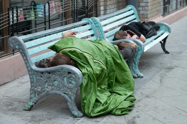 Sem-abrigo dorme num banco num dia frio de Outono num parque no país mais pobre da União Europeia Bulgária . — Fotografia de Stock