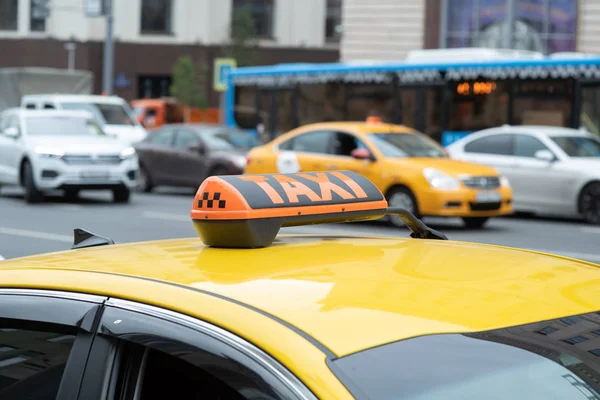 Taxi amarillo con letrero de taxi en el techo estacionado en la calle de la ciudad esperando a que los pasajeros lo recojan.El taxi está estacionado en la calle de la gran ciudad.Enfócate en el icono de la lámpara amarilla — Foto de Stock