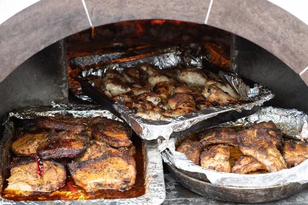 Bandejas de carne cozida no forno sobre as brasas . — Fotografia de Stock
