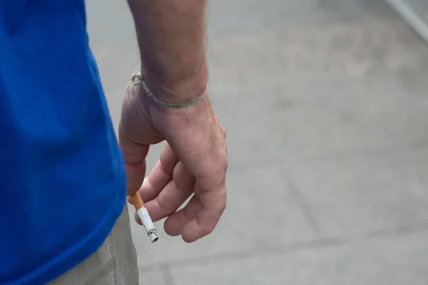 煙でタバコを持っている若い男の手喫煙の害コピースペースを閉じる — ストック写真