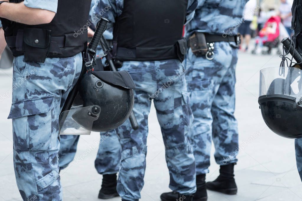 Police squad with helmets, body armor and batons close-up
