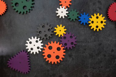 Koyu ahşap arka plan üzerinde plastik konstrüktör dişli çarklar. Popüler oyuncaklar. Copyspace