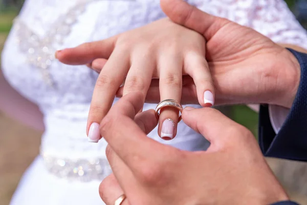 Αγάπη και γάμος. Γαμήλια τελετή. Κοντινό πλάνο του γαμπρού να βάζει χρυσό δαχτυλίδι στο δάχτυλο της νύφης. — Φωτογραφία Αρχείου