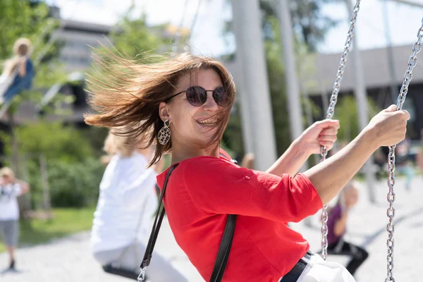 Feliz adolescente chica divertirse en swing sol bengala — Foto de Stock