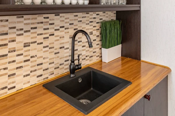 Siyah mutfak lavabo. Siyah mutfak dolapları ile tavan arasındaki modern mutfak