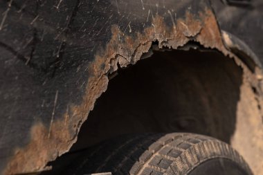Araba parçalarında metal plak, paslı delikler, tamir izleri, yakın çekim