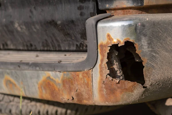 Placa de metal en las piezas del coche, agujeros oxidados, rastros de reparación, primer plano — Foto de Stock