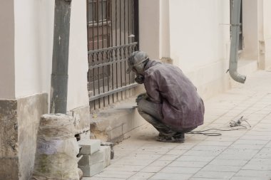 Granit bir taşlama makinesi kullanarak işler bir işçi closeup. Toz ve kırıkları taraf için sinek.