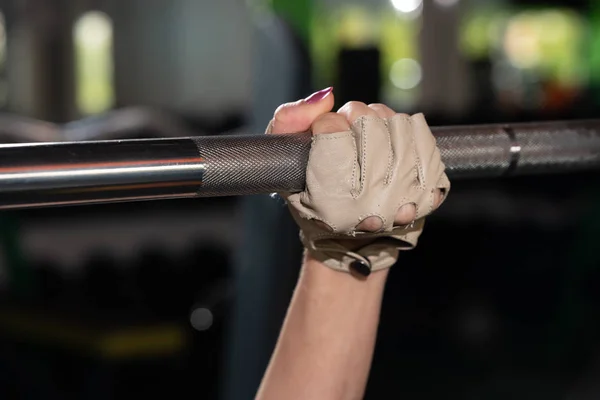 Mujer joven fuerte con hermoso cuerpo atlético haciendo ejercicios con barra. Fitness, musculación. Asistencia sanitaria. — Foto de Stock