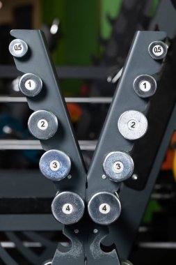 Spor salonunda halterlerle, halter setinde dur. Fitness kulübünde birçok dumbbells