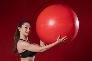 İsviçre balosunda elinde egzersiz yapıp kameraya gülümseyen genç bir kadının portresi. Canlı kadın fitness modeli görüntü