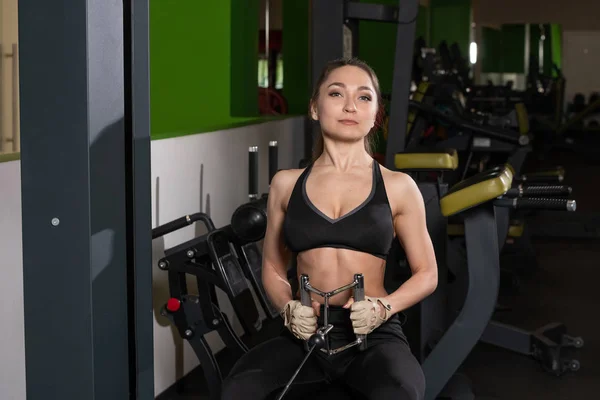 Joven fitness mujer ejecutar ejercicio con máquina de ejercicio Cable Crossover en el gimnasio, foto horizontal — Foto de Stock